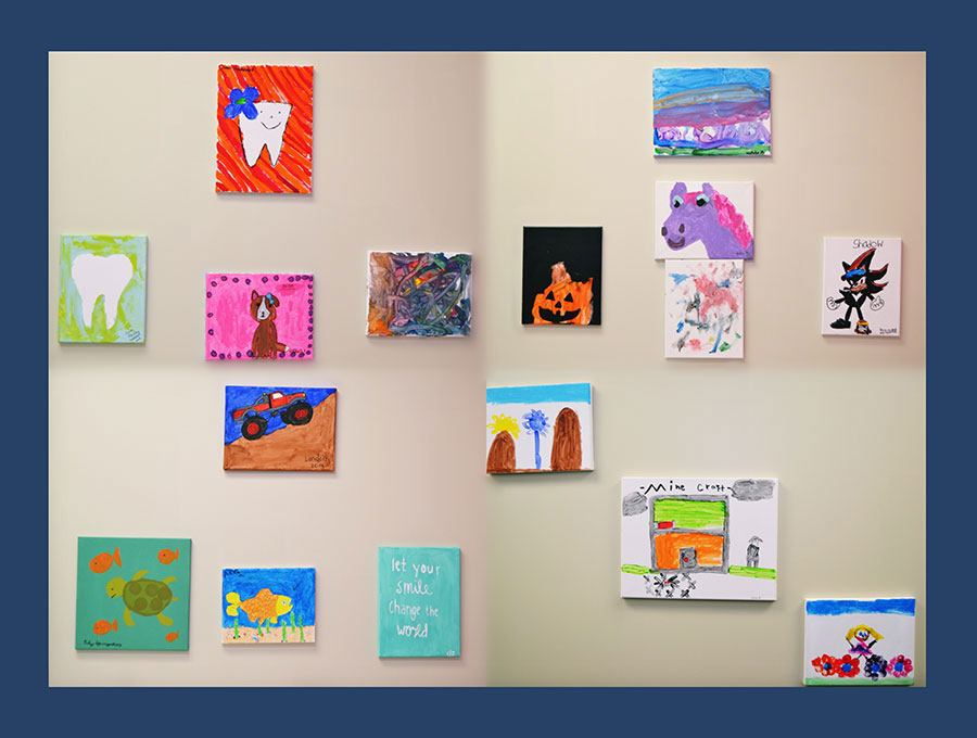 The image shows a collection of colorful paintings displayed on a wall, with various subjects such as animals, nature scenes, and abstract art, each painting framed and hung at different heights.