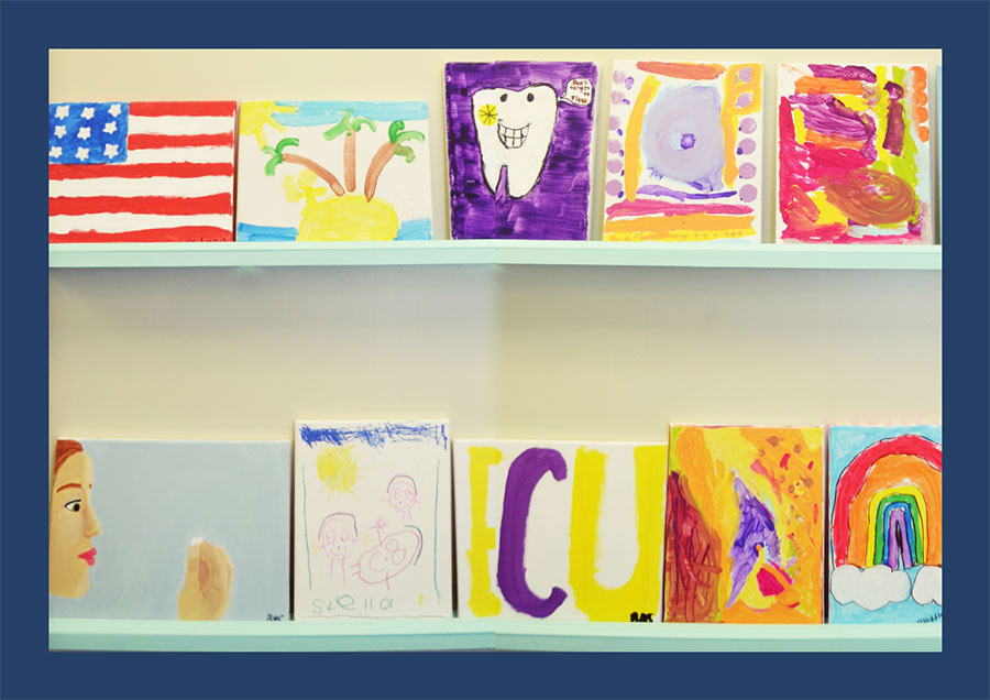 The image shows a collection of colorful paintings displayed on a shelf, with various subjects including portraits, landscapes, and abstract art pieces.