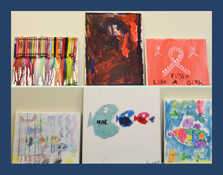 The image shows a collection of colorful handmade artworks displayed on a wall against a white background.