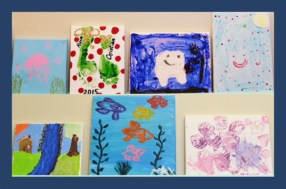 The image displays a collection of colorful paintings or artwork with various themes, including marine life, nature, and abstract designs, arranged on a surface for display.